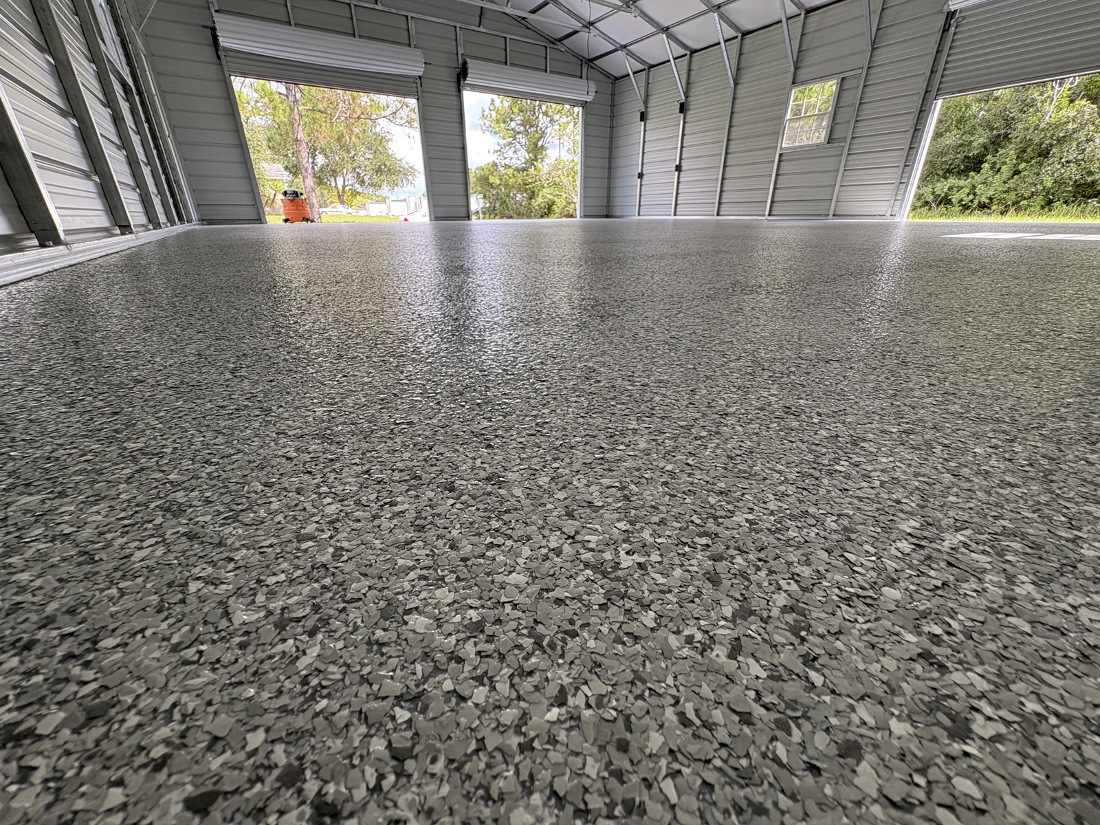 Flake epoxy floor in a metal workshop building by DJ Epoxy Solutions